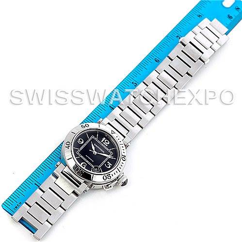 The Cartier Pasha W31077M7 Men
s Stainless Steel Black Dial W31077M7 Men
s Stainless Steel Black Dial watch is shown from a top-down view, displaying the entire watch and its metal bracelet alongside a blue ruler.