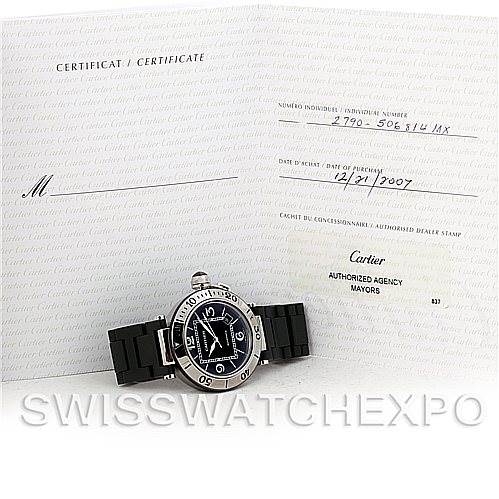 The image shows a Cartier Pasha W31077U2 Men's Stainless Steel Black Dial W31077U2 Men's Stainless Steel Black Dial watch with a black strap, placed in front of an open certificate.