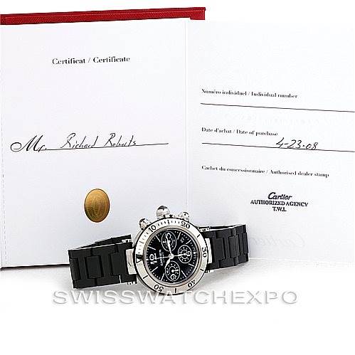 The image shows a Cartier Pasha W31088U2 Men
s Stainless Steel Black Dial W31088U2 Men
s Stainless Steel Black Dial watch with a black band, placed in front of its certification documents.