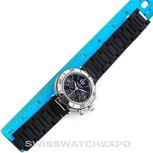 The image shows a top-down view of a Cartier Pasha W31088U2 Men
s Stainless Steel Black Dial W31088U2 Men
s Stainless Steel Black Dial watch with a black strap next to a blue ruler for size reference.