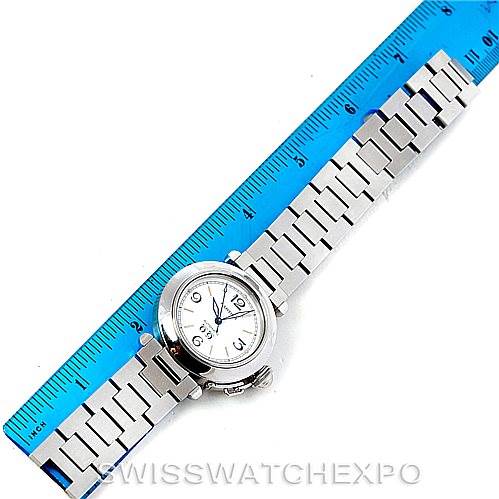 The image shows an aerial view of a Cartier Pasha Stainless Steel Silver Dial Stainless Steel Silver Dial watch with its silver bracelet placed next to a blue ruler.