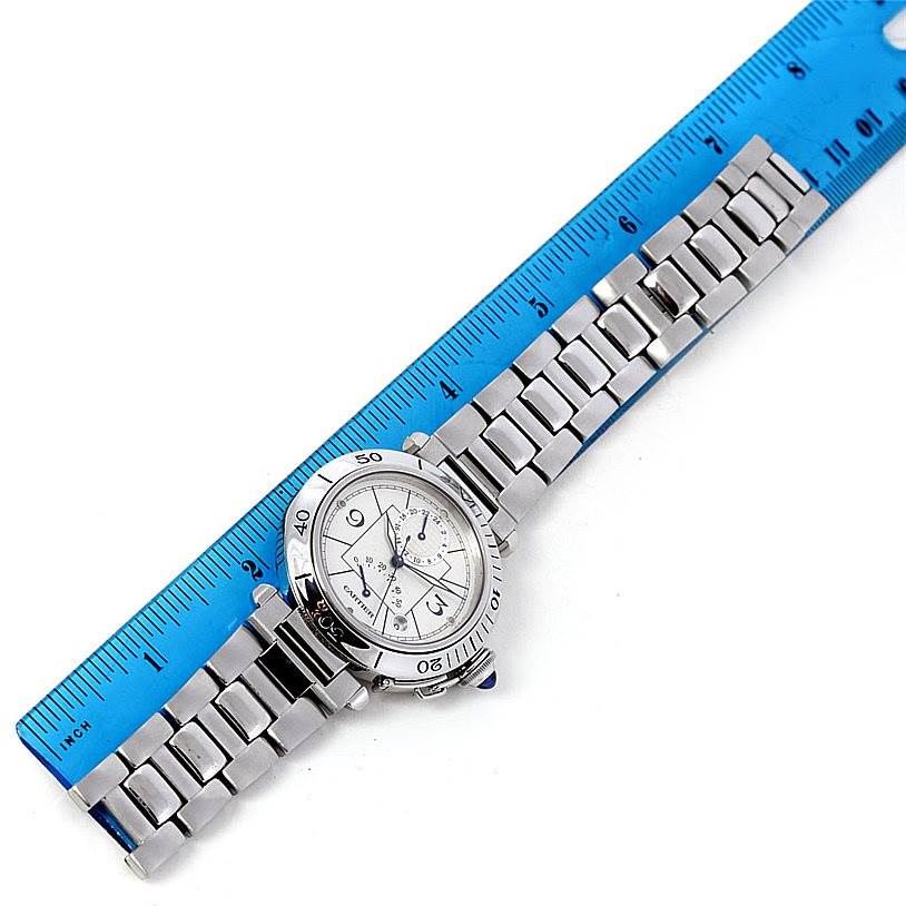 The image shows a Cartier Pasha W31037H3 Men's Stainless Steel Silver Dial W31037H3 Men's Stainless Steel Silver Dial watch positioned next to a ruler, revealing the watch face and full metal bracelet.