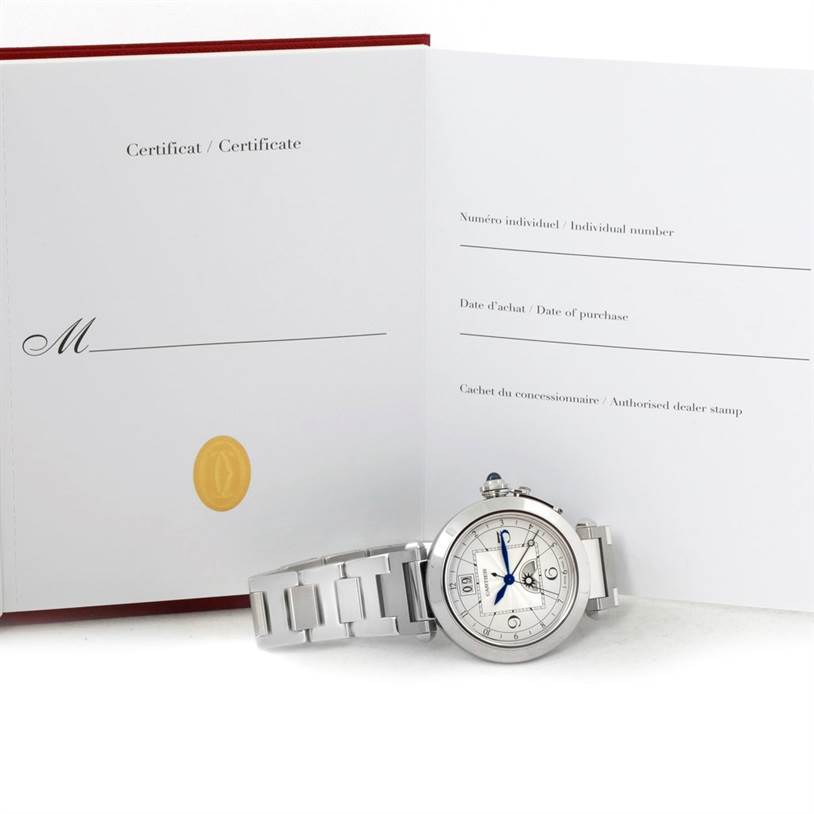 The image shows a Cartier Pasha W31093M7 Men's Stainless Steel Silver Dial W31093M7 Men's Stainless Steel Silver Dial watch with a metal bracelet and an open Certificate booklet in the background.