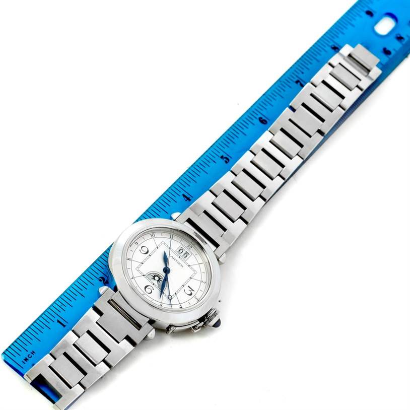 This image shows a top view of the complete Cartier Pasha W31093M7 Men's Stainless Steel Silver Dial W31093M7 Men's Stainless Steel Silver Dial watch, with its bracelet extended alongside a blue ruler.