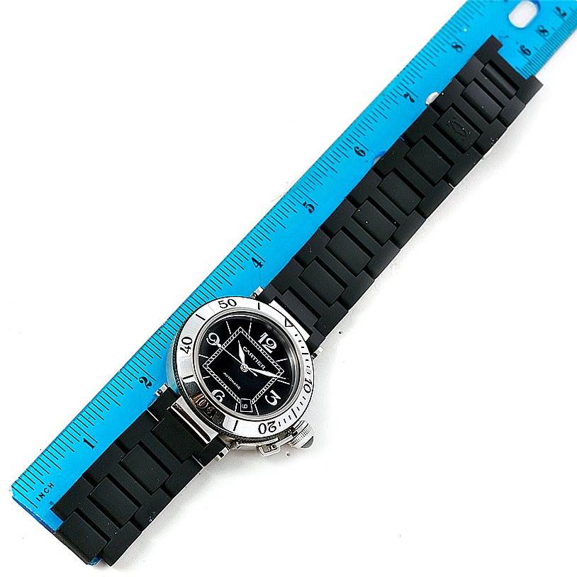 The Cartier Pasha W31077U2 Men
s Stainless Steel Black Dial W31077U2 Men
s Stainless Steel Black Dial watch is shown flat with a blue ruler beside it, displaying the entire watch including the face and strap.