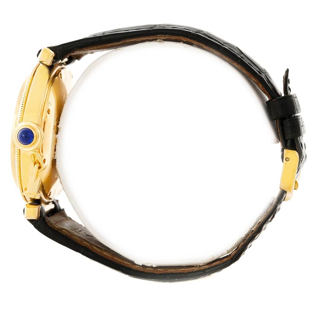 The image shows a side view of a Cartier Pasha Men's Yellow Gold Silver Dial Men's Yellow Gold Silver Dial watch, highlighting its crown with a blue cabochon and black leather strap.