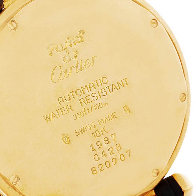 This image shows the back case of a Cartier Pasha Men's Yellow Gold Silver Dial Men's Yellow Gold Silver Dial watch, highlighting its engraved details and specifications.