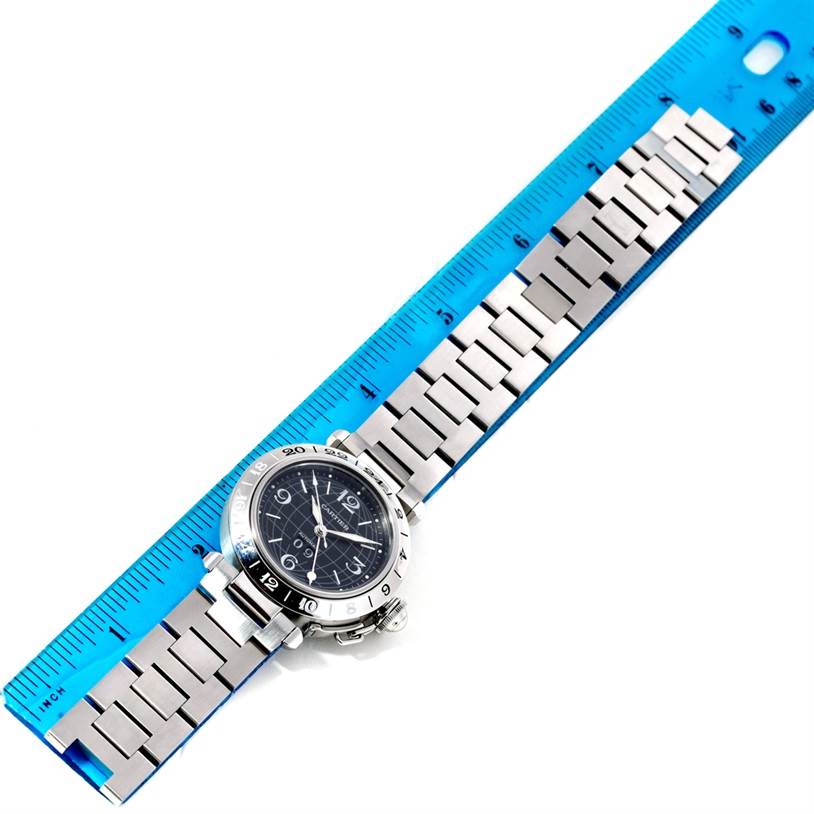 The image shows the Cartier Pasha W31049M7 Men's Stainless Steel Black Dial W31049M7 Men's Stainless Steel Black Dial watch, including its face and metal bracelet, placed alongside a blue ruler for size reference.