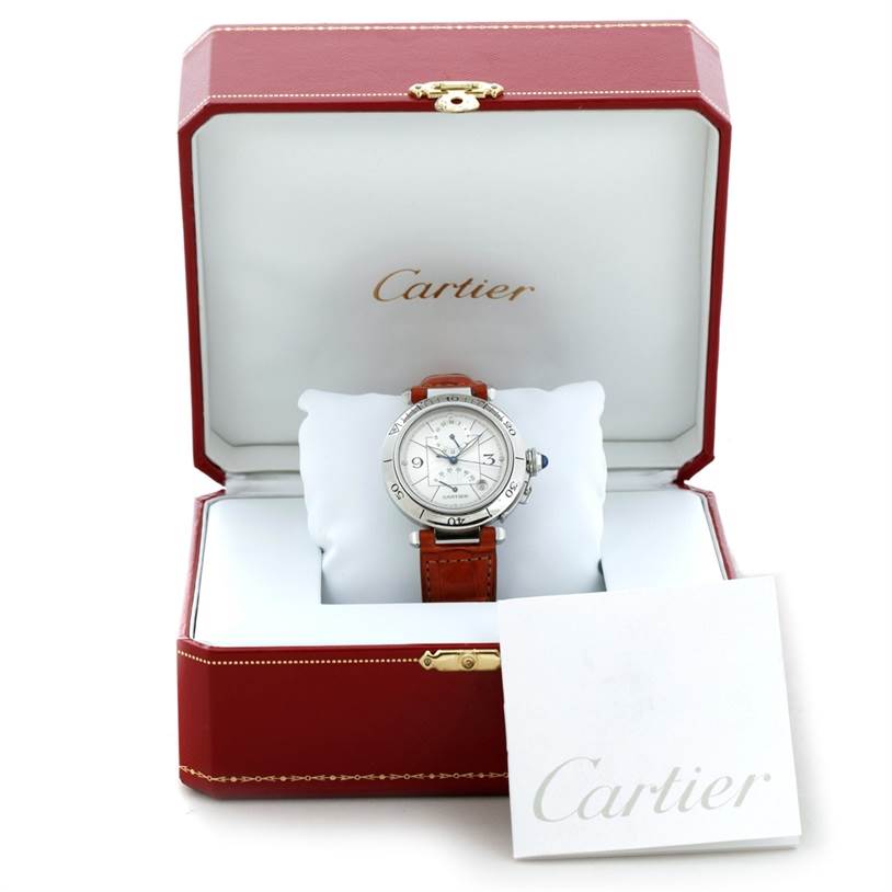 The Cartier Pasha W31037H3 Men's Stainless Steel Silver Dial W31037H3 Men's Stainless Steel Silver Dial watch is displayed front-facing inside an open red Cartier box, with the manual placed nearby.