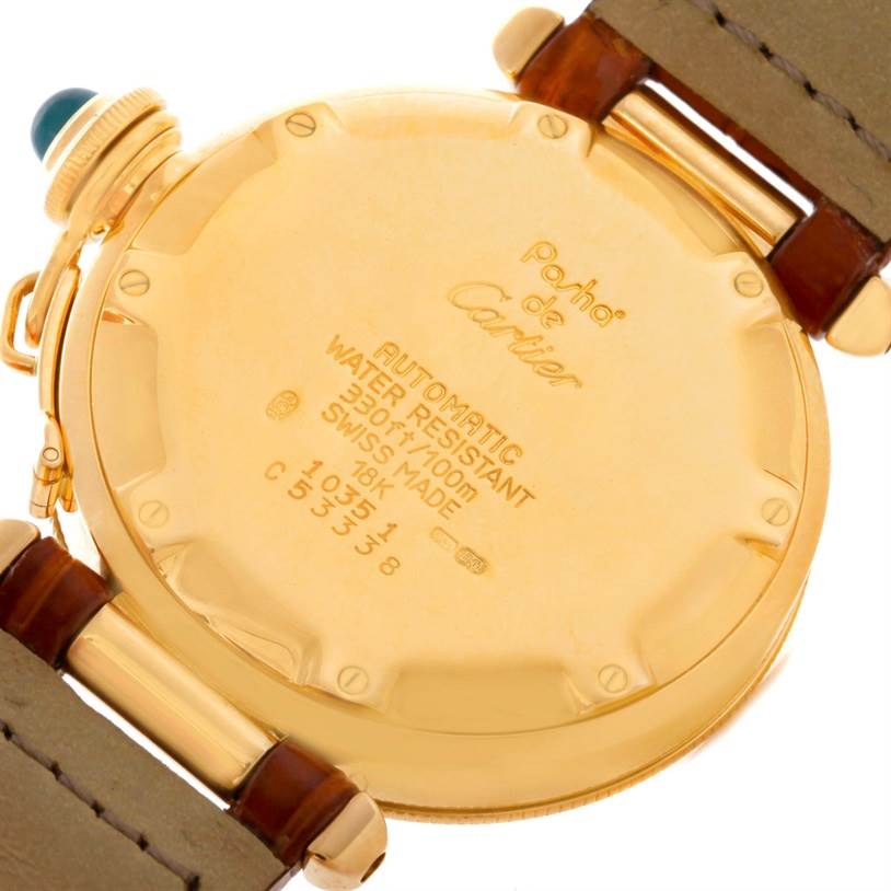 The image shows the back of a Pasha de Cartier watch, highlighting its gold casing and water resistance details.