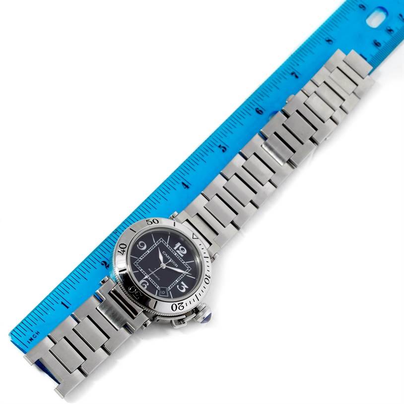 The Cartier Pasha W31077M7 Men
s Stainless Steel Black Dial W31077M7 Men
s Stainless Steel Black Dial watch is shown from a top-down angle, featuring the watch face and metal bracelet placed next to a ruler.