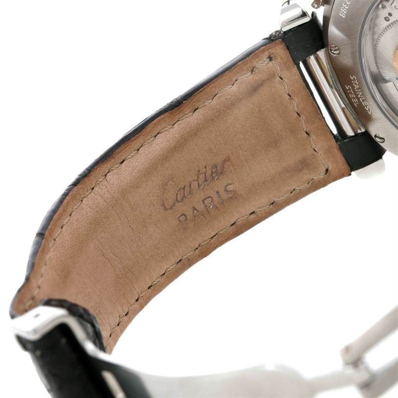 The image shows the underside of a leather strap and part of the case back of a Pasha model by Cartier.
