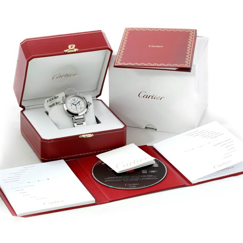 The image shows a Cartier Pasha W31085M7 Men's Stainless Steel Silver Dial W31085M7 Men's Stainless Steel Silver Dial watch in its open red box, accompanied by warranty cards, booklet, and a CD.