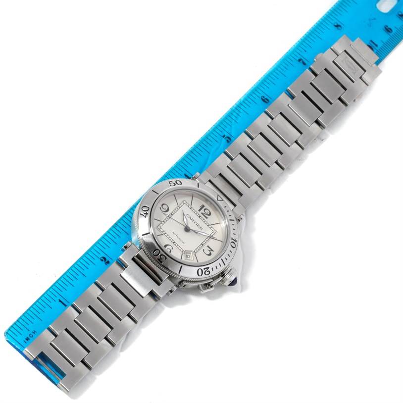 The Cartier Pasha W31080M7 Men
s Stainless Steel Silver Dial W31080M7 Men
s Stainless Steel Silver Dial watch is displayed flat with the face and full metal bracelet in view, alongside a blue ruler.