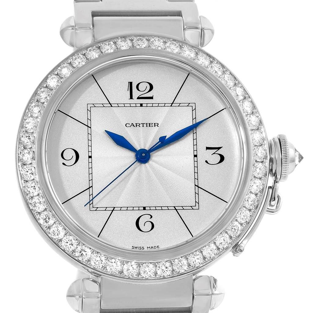 The image shows a frontal view of the Cartier Pasha WJ1202M9 Men's White Gold Silver Dial WJ1202M9 Men's White Gold Silver Dial watch, highlighting its diamond bezel, blue hands, and crown.