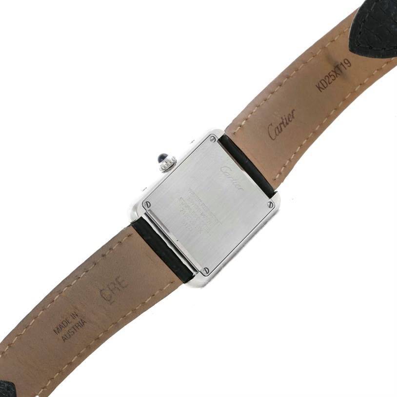 The image shows the back view of the Tank Solo model by Cartier, highlighting the case back and leather strap with inscriptions.