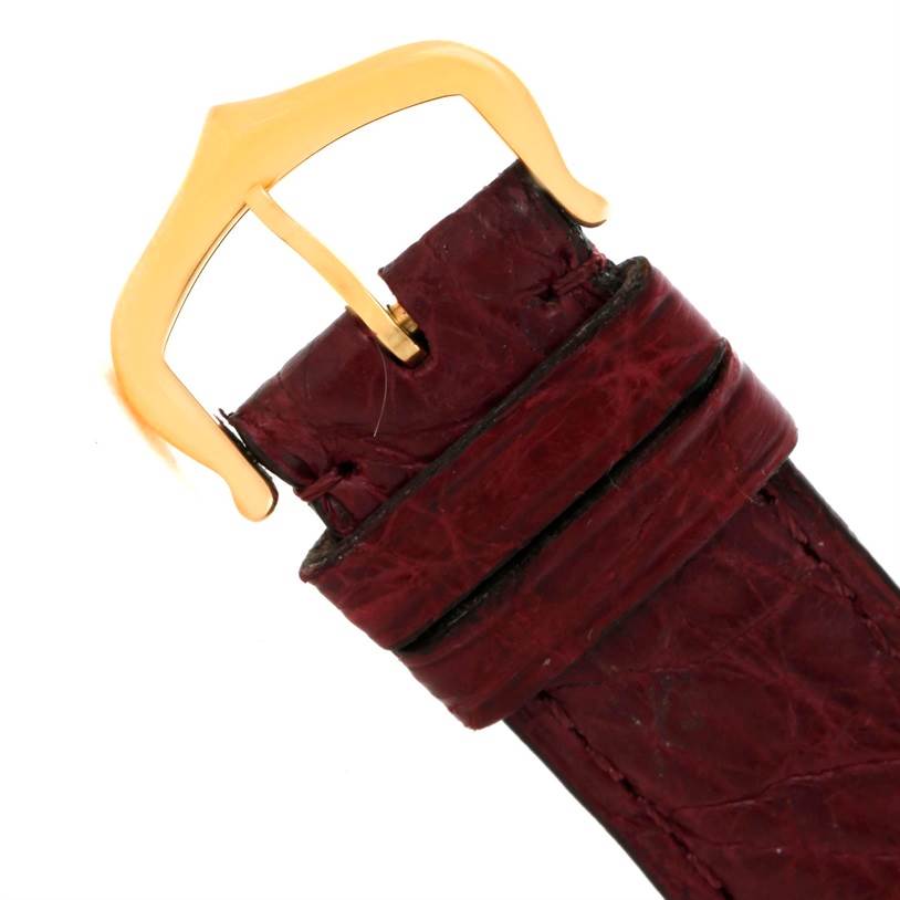 This image shows a close-up of the red leather strap and gold buckle of the Cartier Tank Solo W1018755 Women's Steel and Gold (two tone) Silver Dial W1018755 Women's Steel and Gold (two tone) Silver Dial watch.