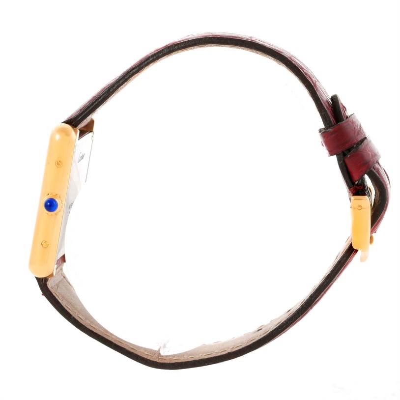 The image shows a side view of the Cartier Tank Solo W1018755 Women's Steel and Gold (two tone) Silver Dial W1018755 Women's Steel and Gold (two tone) Silver Dial watch, including its leather strap and rectangular case with a blue jewel crown.