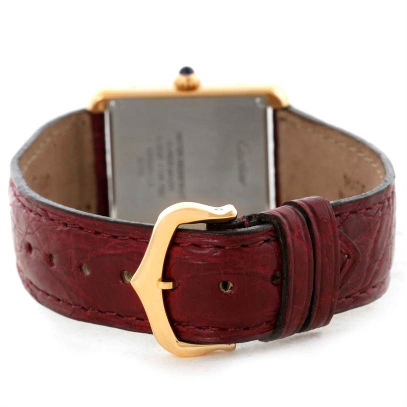 The Cartier Tank Solo W1018755 Women's Steel and Gold (two tone) Silver Dial W1018755 Women's Steel and Gold (two tone) Silver Dial watch is shown from the back, highlighting its case back, red leather strap, and gold buckle.