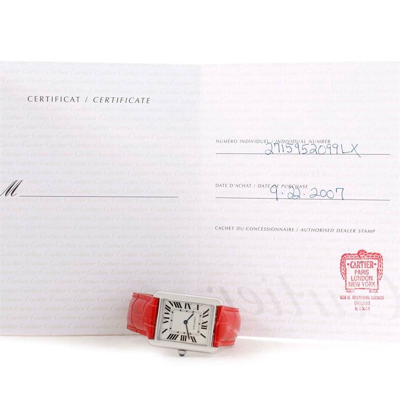 The image shows a Cartier Tank Solo W1018355 Women's Stainless Steel Silver Dial W1018355 Women's Stainless Steel Silver Dial watch with a red strap, placed on an open certificate displaying the purchase date and dealer stamp.
