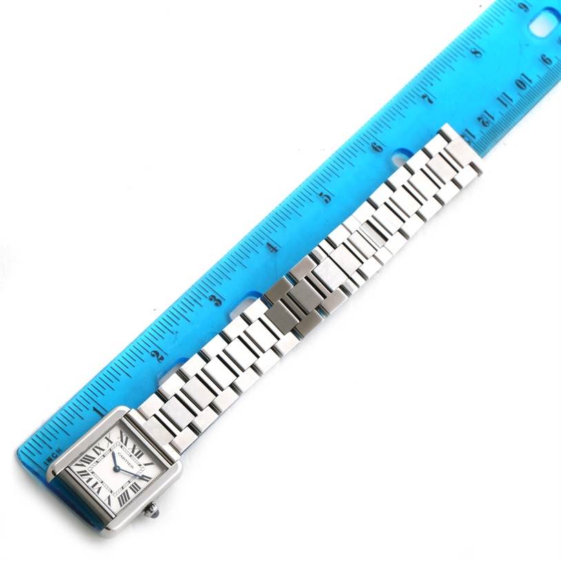 The image shows a Cartier Tank Solo W5200013 Women
s Stainless Steel Silver Dial W5200013 Women
s Stainless Steel Silver Dial watch face and stainless steel bracelet next to a blue ruler for size reference.