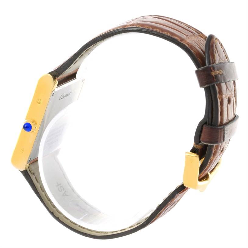 The image shows a side view of the Cartier Tank Solo W1018755 Women's Steel and Gold (two tone) Silver Dial W1018755 Women's Steel and Gold (two tone) Silver Dial watch highlighting the leather strap and the blue cabochon crown.