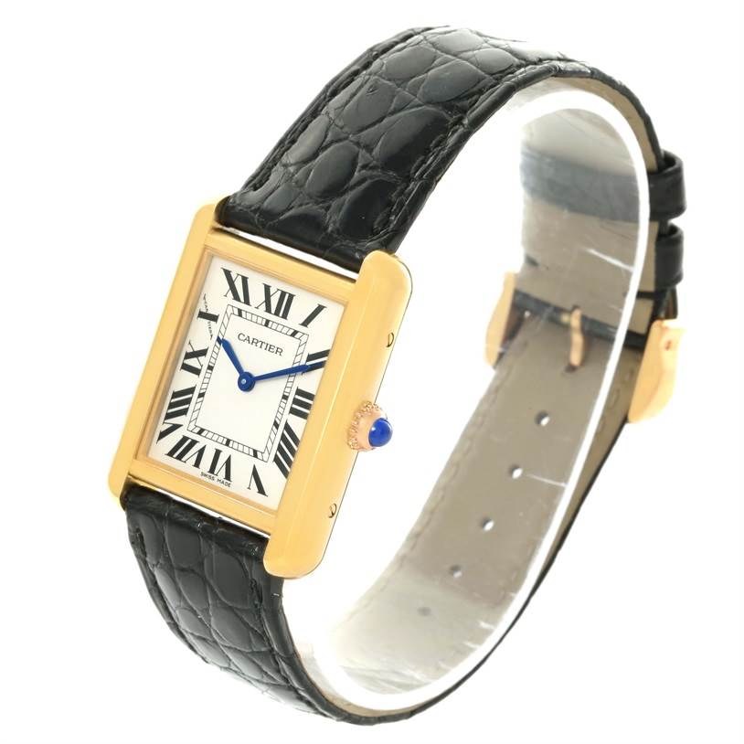 The Cartier Tank Solo W1018755 Women's Steel and Gold (two tone) Silver Dial W1018755 Women's Steel and Gold (two tone) Silver Dial watch is displayed at a diagonal angle, showcasing its face, leather strap, and crown with a blue cabochon.