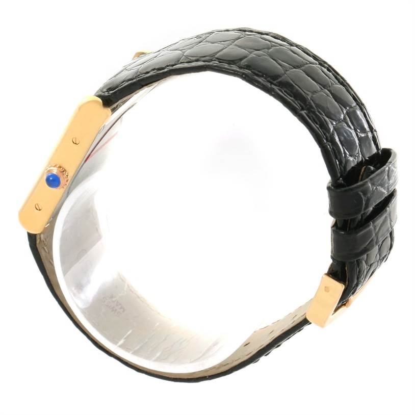 The image shows a side view of a Cartier Tank Solo W1018755 Women's Steel and Gold (two tone) Silver Dial W1018755 Women's Steel and Gold (two tone) Silver Dial watch, highlighting the black leather strap and gold case with a blue cabochon crown.