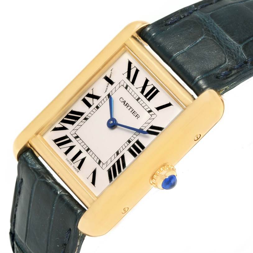 The image shows a Cartier Tank Solo W1018755 Women's Steel and Gold (two tone) Silver Dial W1018755 Women's Steel and Gold (two tone) Silver Dial watch with a gold case, Roman numerals, blue hands, and a blue alligator strap, angled slightly from the front.