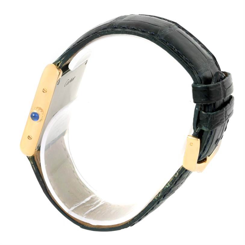 This image shows a Cartier Tank Solo W1018755 Women's Steel and Gold (two tone) Silver Dial W1018755 Women's Steel and Gold (two tone) Silver Dial watch from a side angle, highlighting the strap, buckle, and side view of the case with its blue cabochon crown.