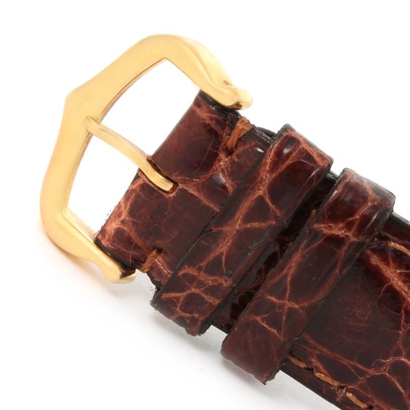 The image shows a close-up angle of a brown leather strap and gold buckle from a Tank Solo watch by Cartier.