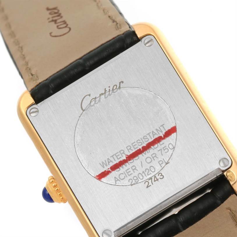 The image shows the back case and leather strap of a Cartier Tank Solo W1018755 Women's Steel and Gold (two tone) Silver Dial W1018755 Women's Steel and Gold (two tone) Silver Dial watch, focusing on the inscriptions and crown.