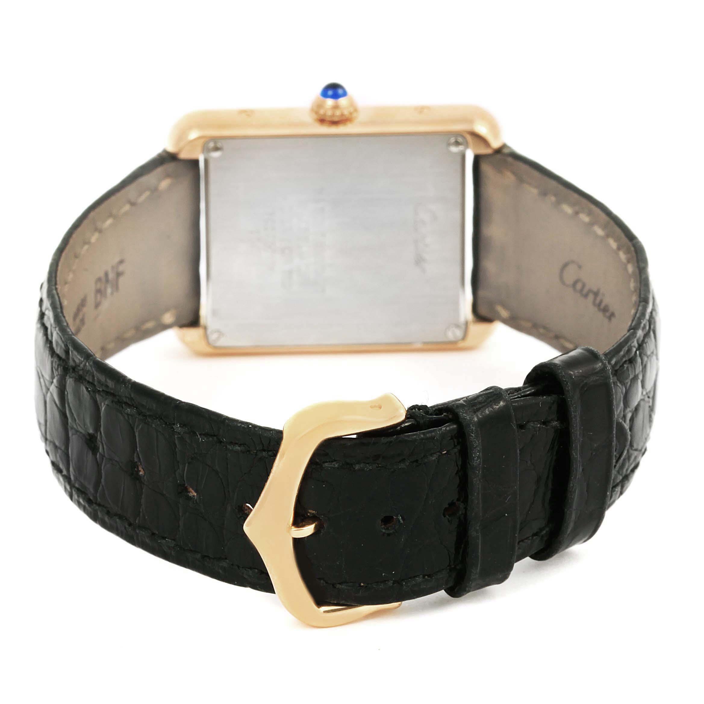 The image shows the back view of the Cartier Tank Solo W1018755 Women
s Steel and Gold (two tone) Silver Dial W1018755 Women
s Steel and Gold (two tone) Silver Dial watch, highlighting its leather strap, gold buckle, and case back.