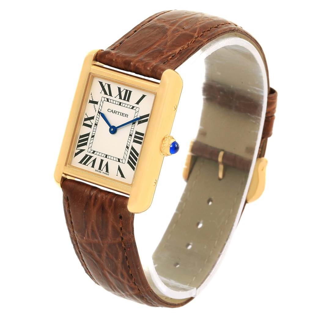 The Cartier Tank Solo W1018755 Women's Steel and Gold (two tone) Silver Dial W1018755 Women's Steel and Gold (two tone) Silver Dial watch is shown at an angle, displaying its rectangular face, leather strap, and crown with a blue cabochon.