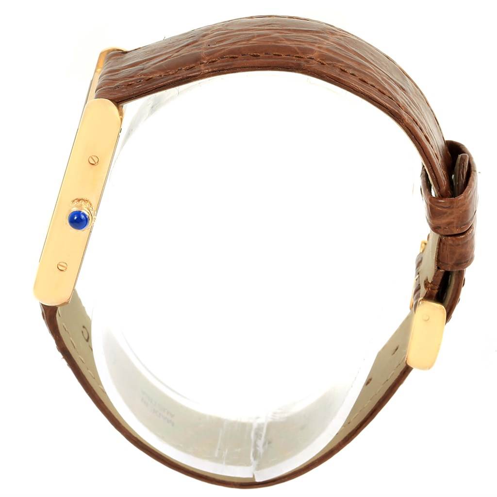 The image shows a side view of the Cartier Tank Solo W1018755 Women's Steel and Gold (two tone) Silver Dial W1018755 Women's Steel and Gold (two tone) Silver Dial watch highlighting its brown leather strap and gold case with a blue cabochon crown.