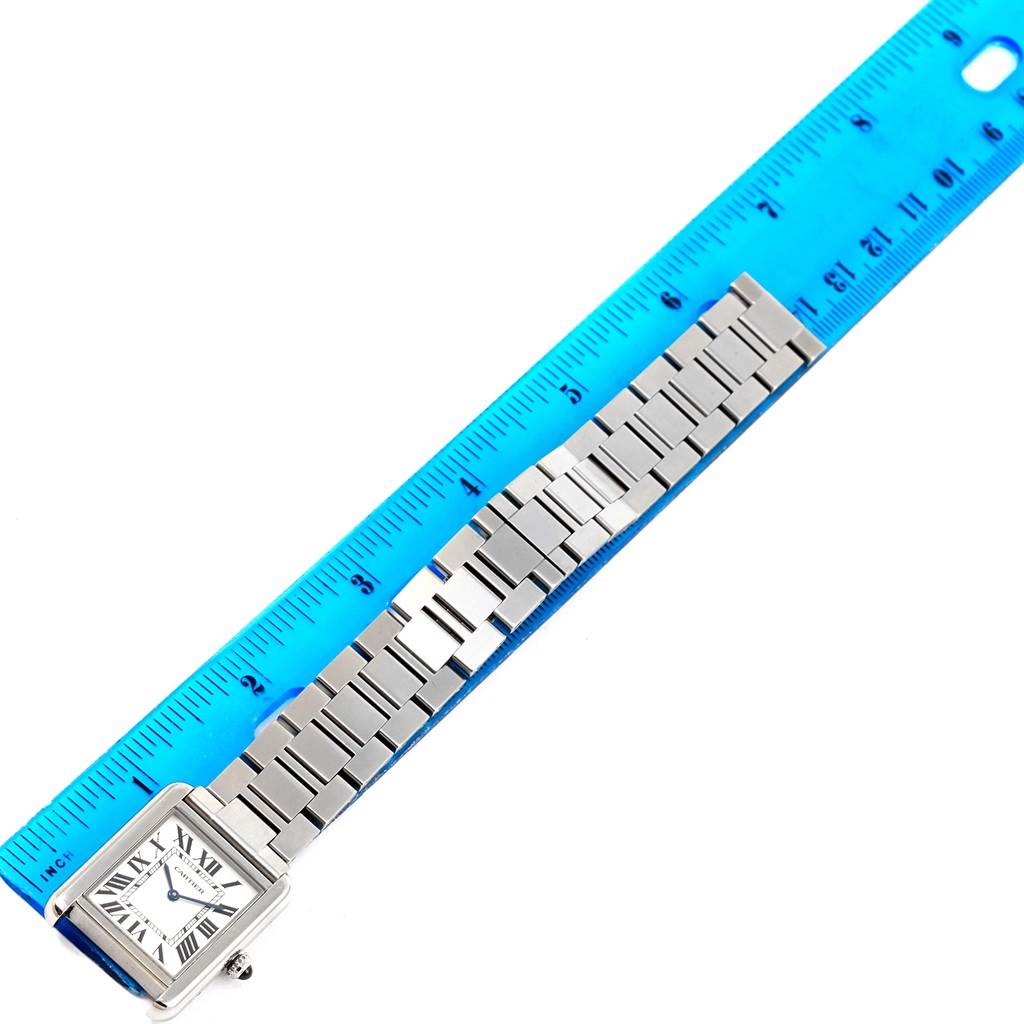 The image shows a Cartier Tank Solo W5200013 Women
s Stainless Steel Silver Dial W5200013 Women
s Stainless Steel Silver Dial watch laid flat next to a blue ruler, displaying the face and metal band.