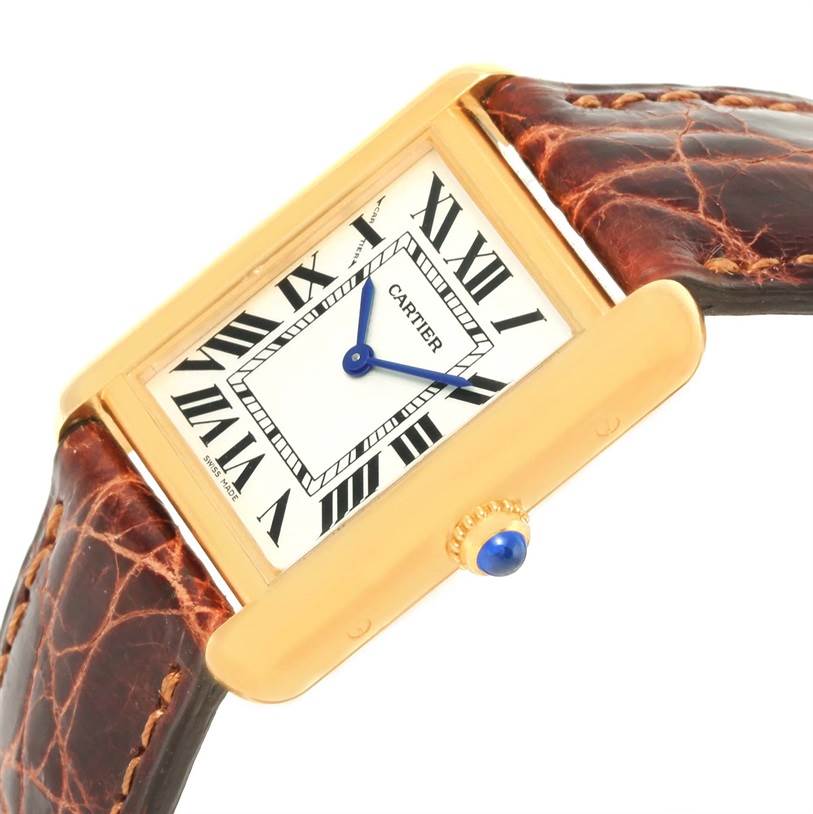 The Cartier Tank Solo W1018755 Women's Steel and Gold (two tone) Silver Dial W1018755 Women's Steel and Gold (two tone) Silver Dial watch is shown at a tilted angle, highlighting its face, blue hands, Roman numerals, gold case, and brown leather strap.