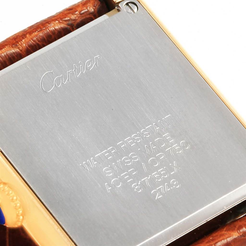 This image shows the back case of a Cartier Tank Solo W1018755 Women's Steel and Gold (two tone) Silver Dial W1018755 Women's Steel and Gold (two tone) Silver Dial watch, with visible engravings and a portion of the strap.