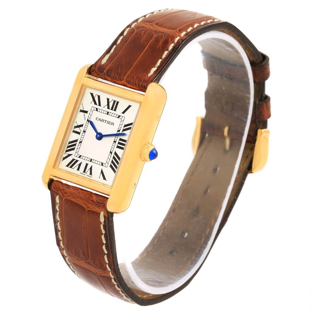The Cartier Tank Solo W1018755 Women's Steel and Gold (two tone) Silver Dial W1018755 Women's Steel and Gold (two tone) Silver Dial watch is shown at a slightly tilted angle, featuring its rectangular dial, brown leather strap, and blue cabochon crown.