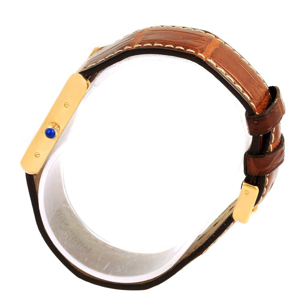 This image shows a side view of the Cartier Tank Solo W1018755 Women's Steel and Gold (two tone) Silver Dial W1018755 Women's Steel and Gold (two tone) Silver Dial watch focusing on its gold case, the blue cabochon crown, and brown leather strap.