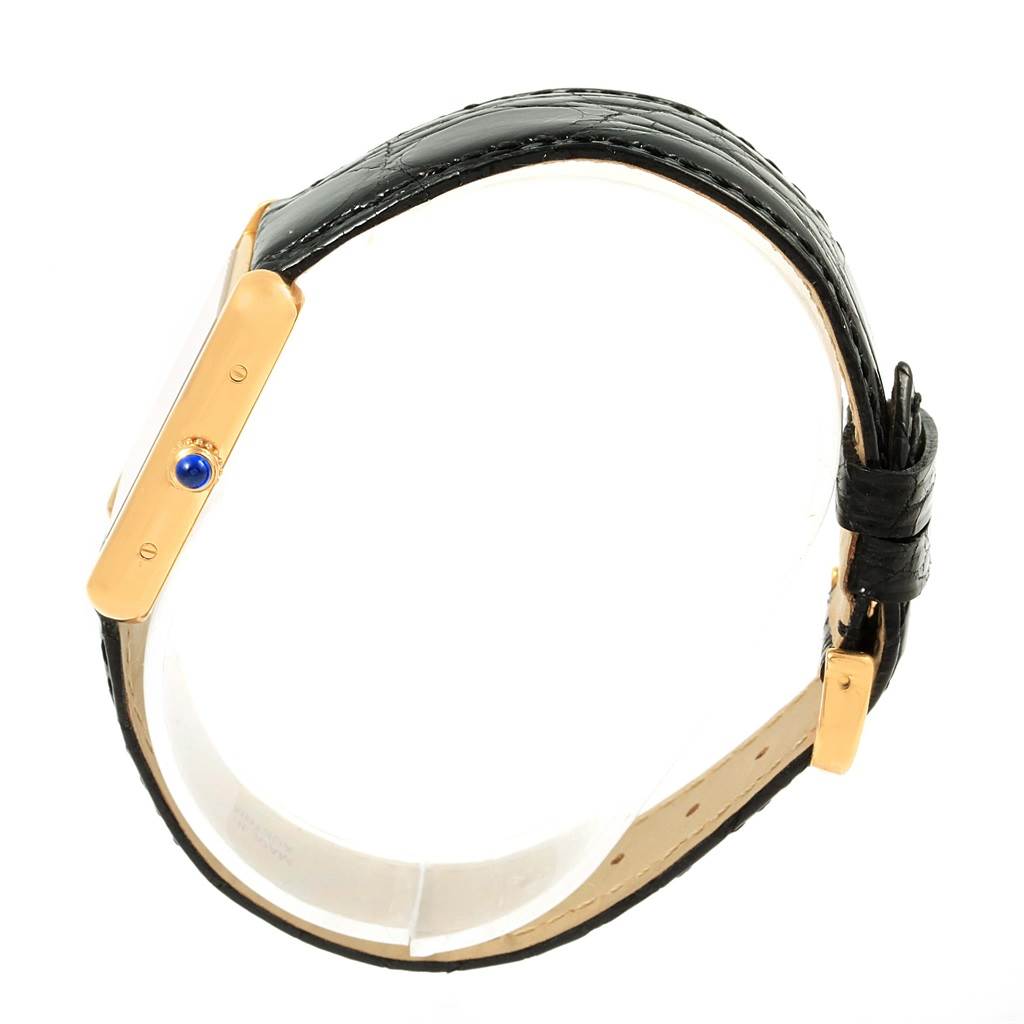 This image shows a side view of the Cartier Tank Solo W1018755 Women's Steel and Gold (two tone) Silver Dial W1018755 Women's Steel and Gold (two tone) Silver Dial watch, highlighting its black strap and the blue gemstone crown.