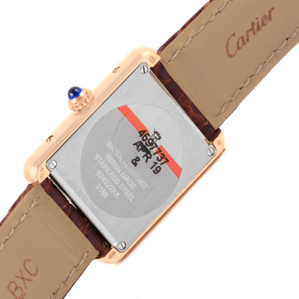 The image shows the back of a Cartier Tank Solo W5200024 Women's Steel and Gold (two tone) Silver Dial W5200024 Women's Steel and Gold (two tone) Silver Dial watch, displaying the case back, straps, and the crown with a blue stone.