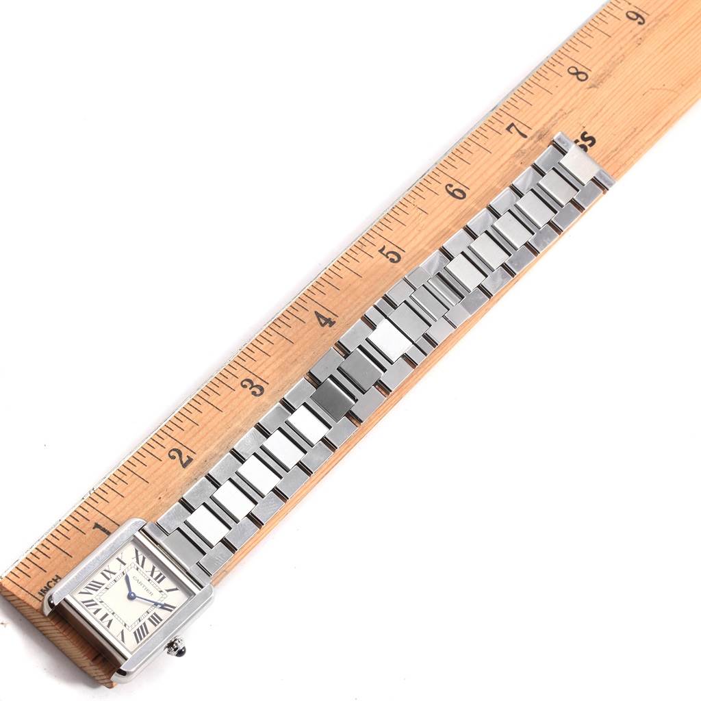 The Cartier Tank Solo W5200013 Women's Stainless Steel Silver Dial W5200013 Women's Stainless Steel Silver Dial watch is shown from a top-down angle, displaying its dial, case, and metal bracelet next to a ruler.