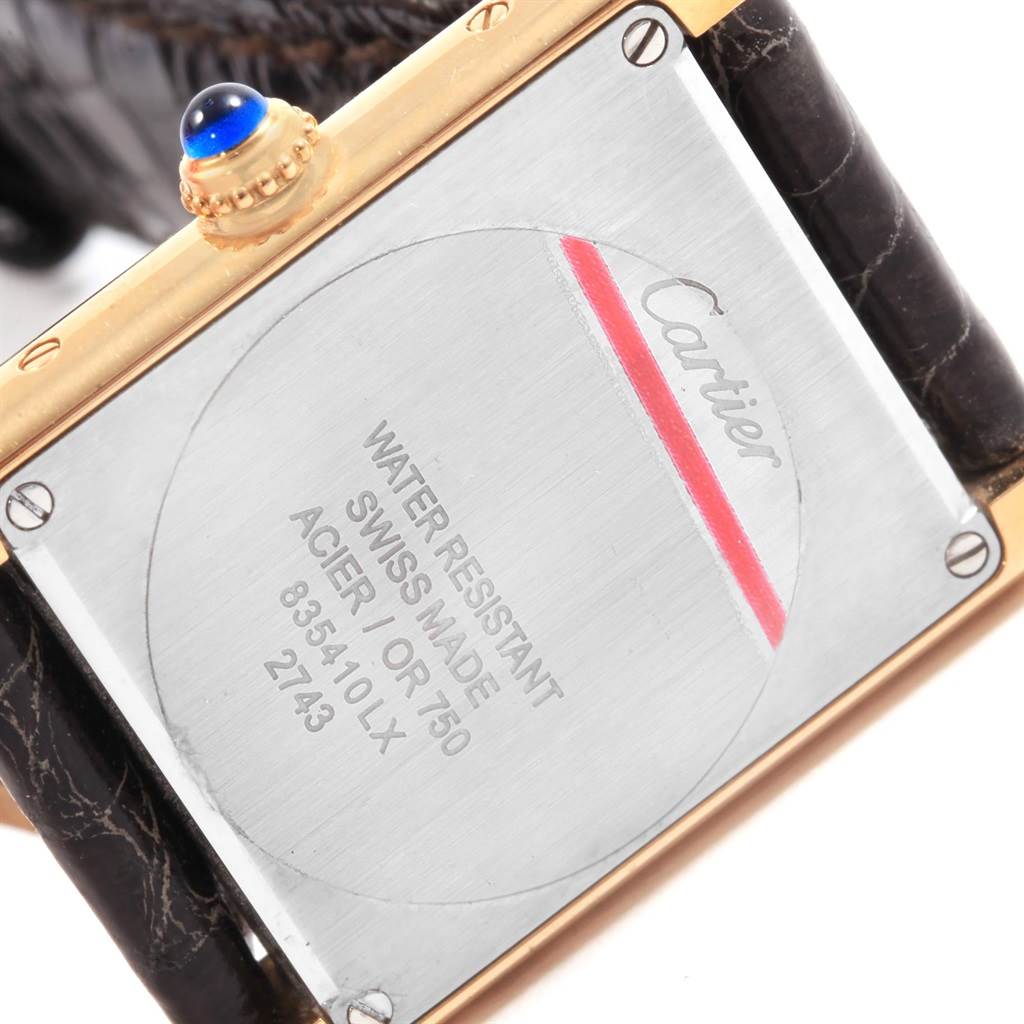 The image shows the back case of a Cartier Tank Solo W1018755 Women's Steel and Gold (two tone) Silver Dial W1018755 Women's Steel and Gold (two tone) Silver Dial watch, revealing its inscriptions and leather strap.