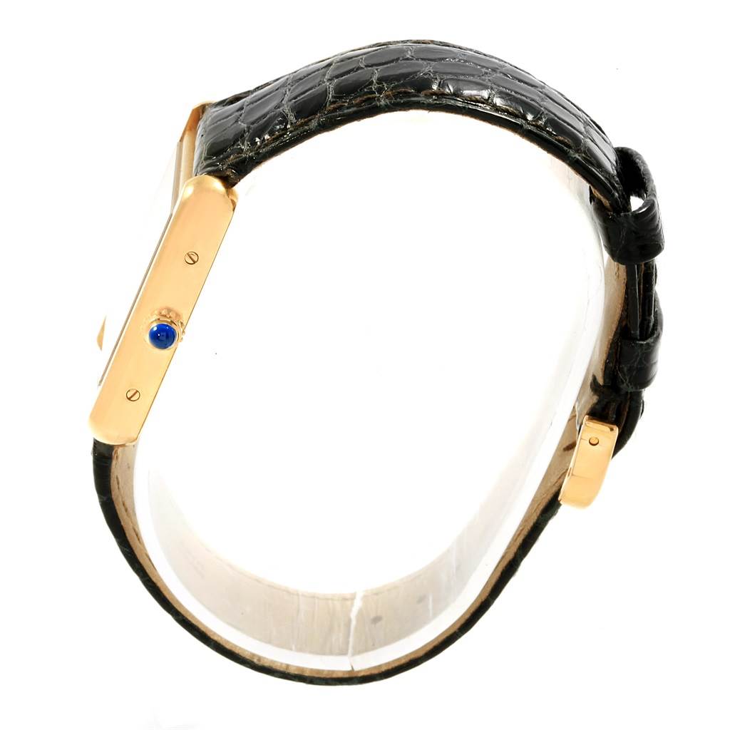 This side view of the Cartier Tank Solo W1018755 Women's Steel and Gold (two tone) Silver Dial W1018755 Women's Steel and Gold (two tone) Silver Dial watch shows the gold case, blue crown, and black leather strap.