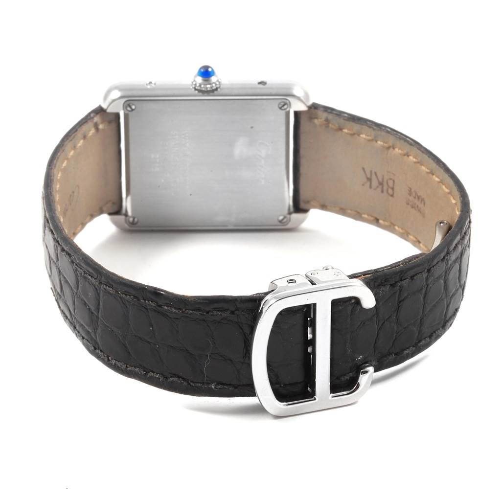 This image shows the back of a Cartier Tank Solo W1018255 Women's Stainless Steel Silver Dial W1018255 Women's Stainless Steel Silver Dial watch, including its square case, blue cabochon crown, and black leather strap with a buckle.