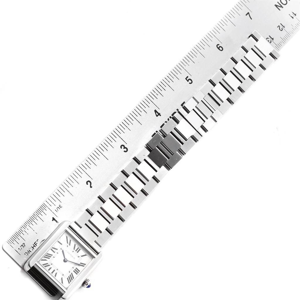 The image shows the Cartier Tank Solo W5200013 Women's Stainless Steel Silver Dial W5200013 Women's Stainless Steel Silver Dial watch laid flat next to a ruler, primarily displaying its face and metal bracelet.