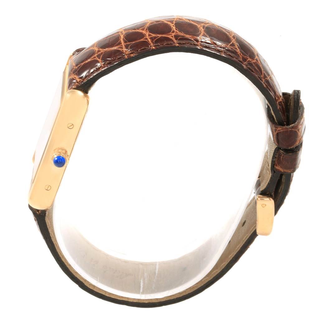 The image shows a side view of a Cartier Tank Solo W1018755 Women's Steel and Gold (two tone) Silver Dial W1018755 Women's Steel and Gold (two tone) Silver Dial watch, highlighting its brown textured strap, gold case, and blue cabochon crown.