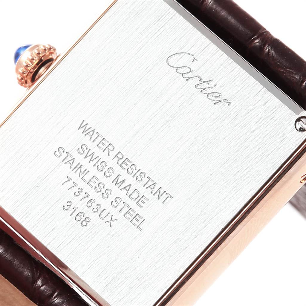 This image shows the back case of a Cartier Tank Solo W5200024 Women's Steel and Gold (two tone) Silver Dial W5200024 Women's Steel and Gold (two tone) Silver Dial watch, highlighting the inscription and a part of the leather strap.