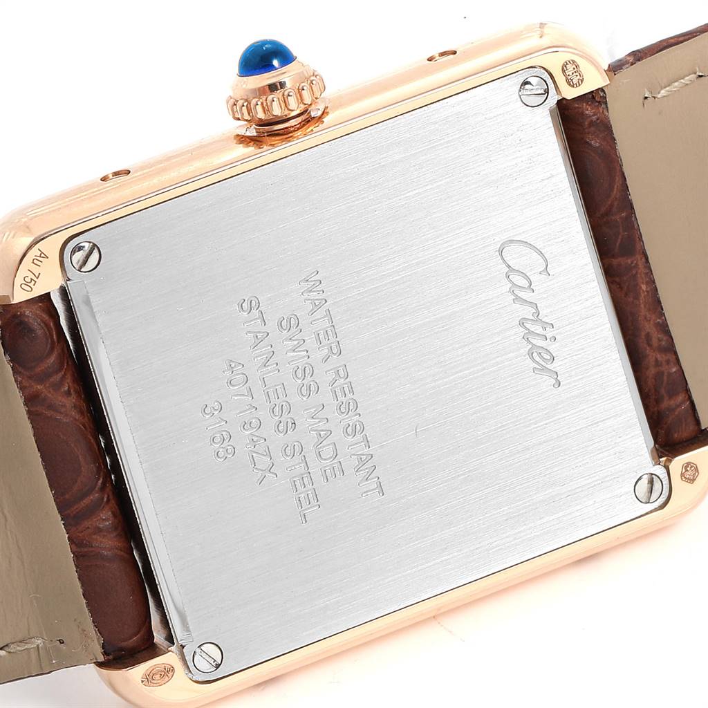 The image shows the back case and part of the strap of a Cartier Tank Solo W5200024 Women's Steel and Gold (two tone) Silver Dial W5200024 Women's Steel and Gold (two tone) Silver Dial watch, featuring a blue cabochon crown.